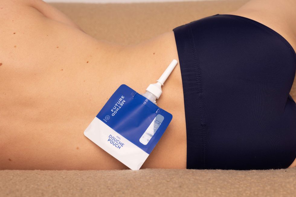 Sing-use douche kit against a man's back who is wearing underwear