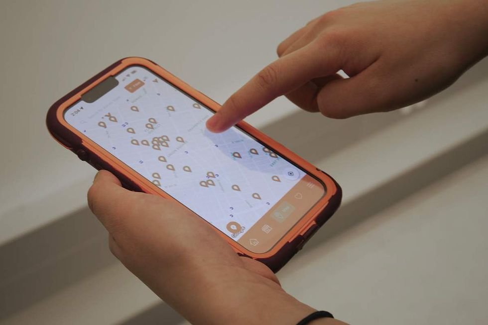 Someone using the Everywhere is Queer app on a mobile phone.