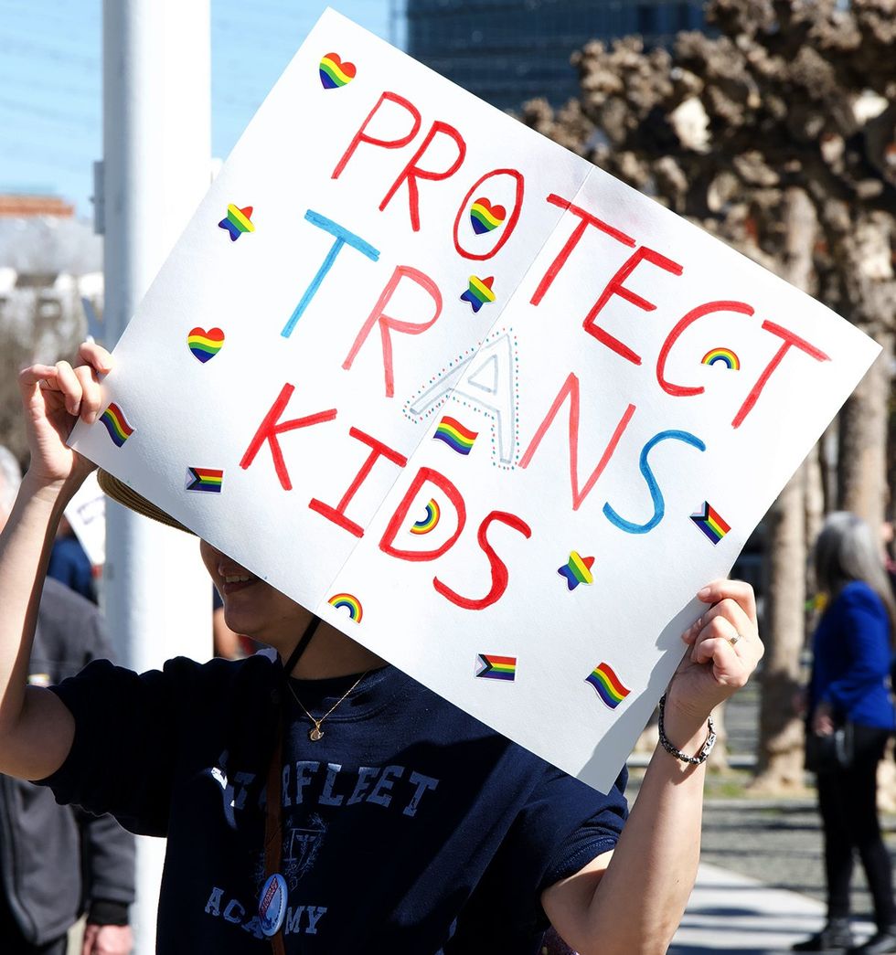 Stand Up for Science Protest Rally in front of City Hall person holding protect trans kids sign