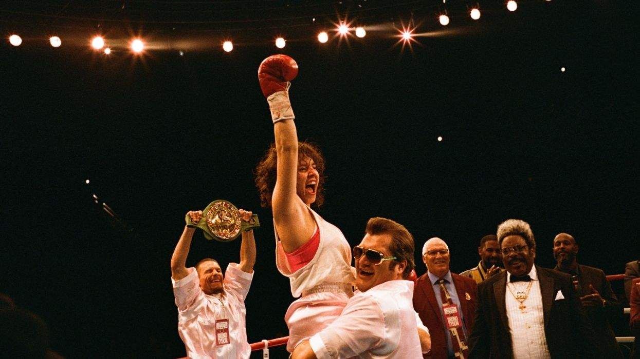 Sydney Sweeney raising a fist in the air while being lifted up