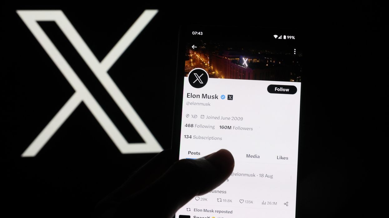 The X symbol next to a hand holding a phone with the X app on the screen