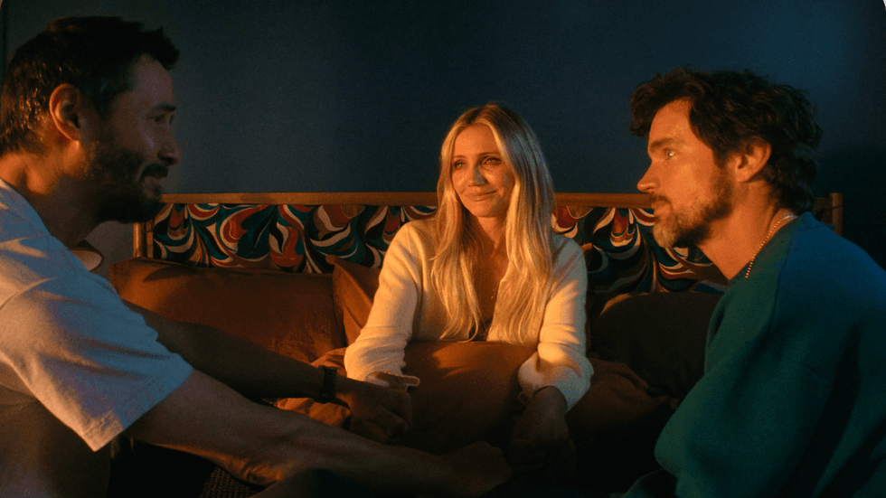 Three people sitting in bed together