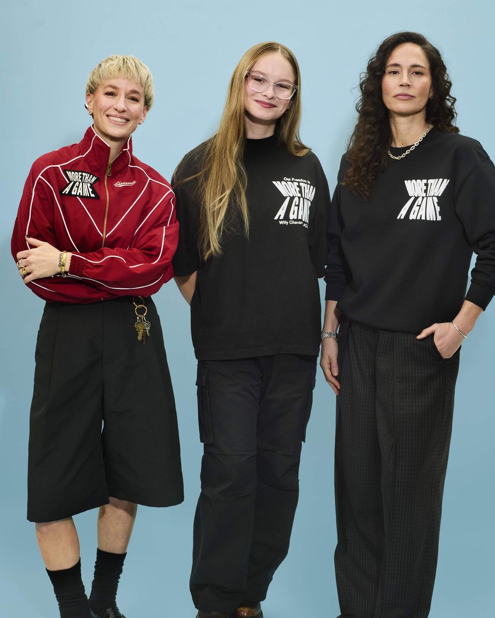 Three women posing for a photo in front of a blue background