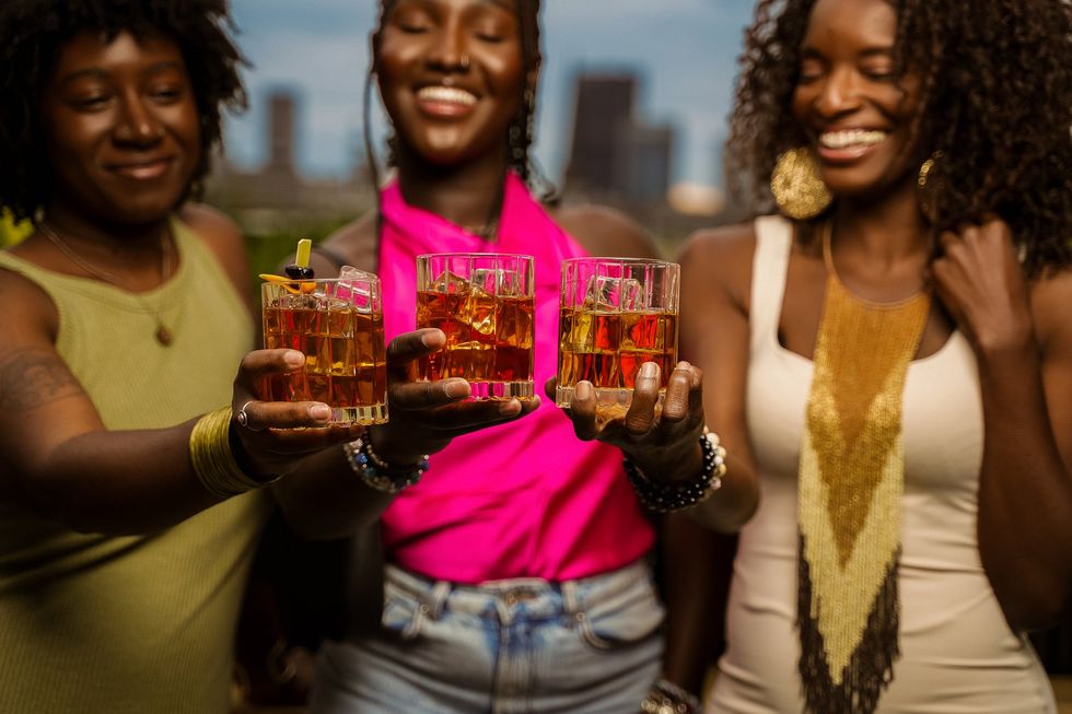 Three women toast with bourbon.