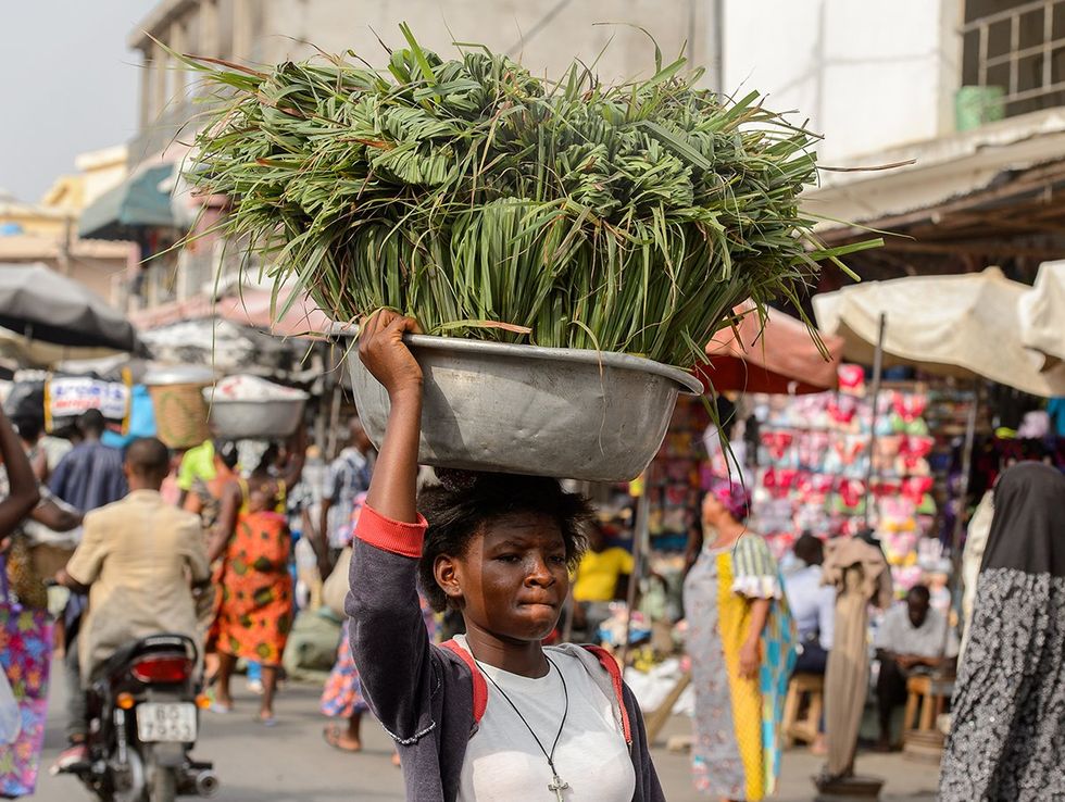 Togolese woman carries a basin on her head at the Lome central market