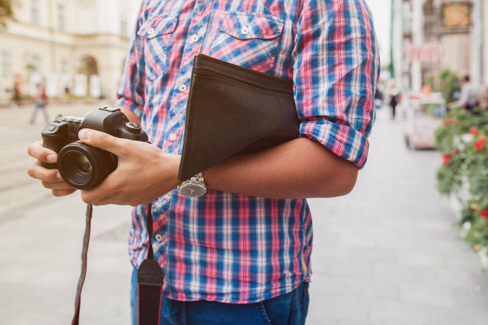 tourist with camera and wallet on city street