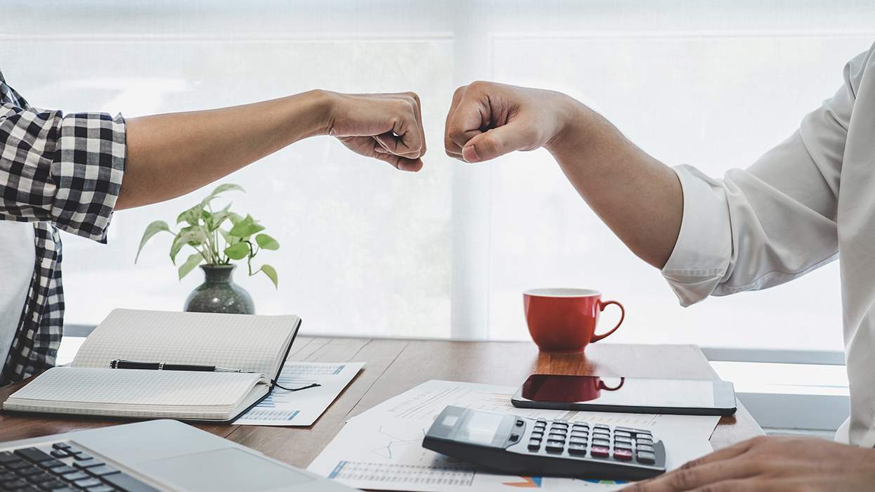 āTwo adults engage in a fist bump.