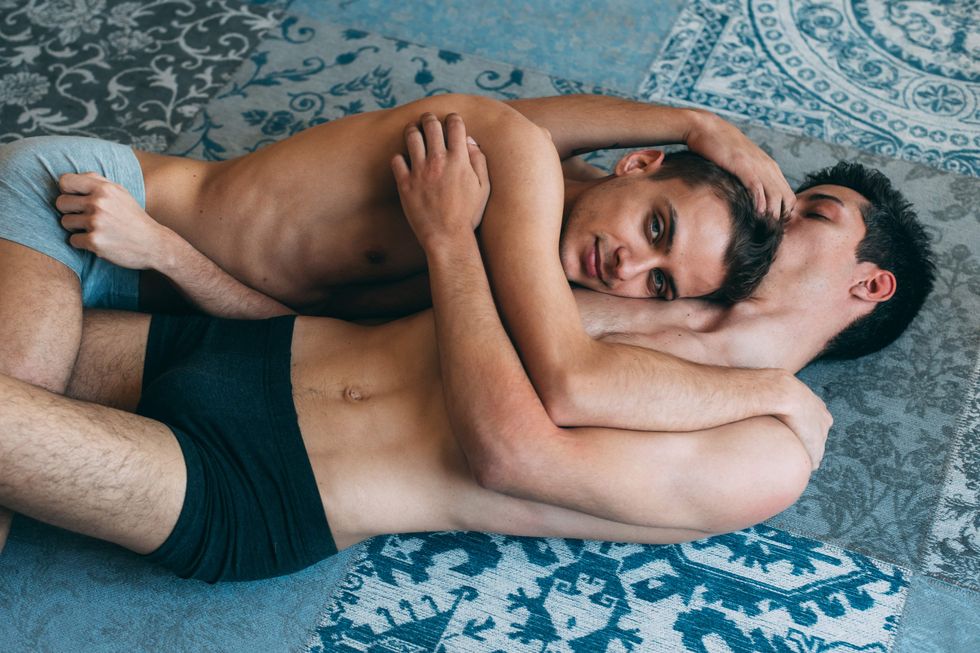 Two gay men holding each other on the carpet