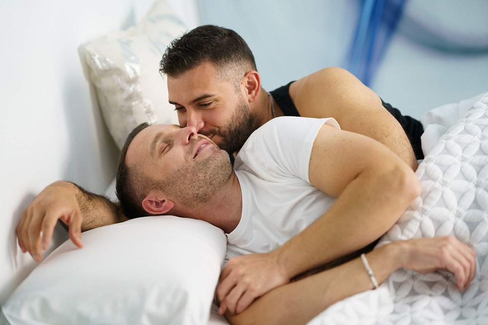 Two gay men spooning.