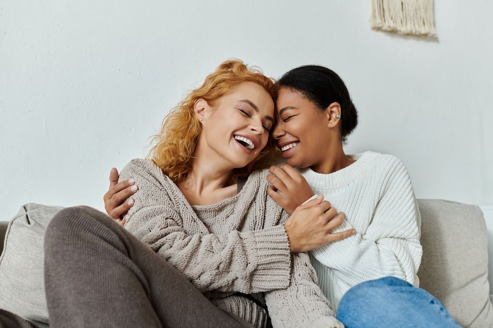 Two lesbians embracing on a couch