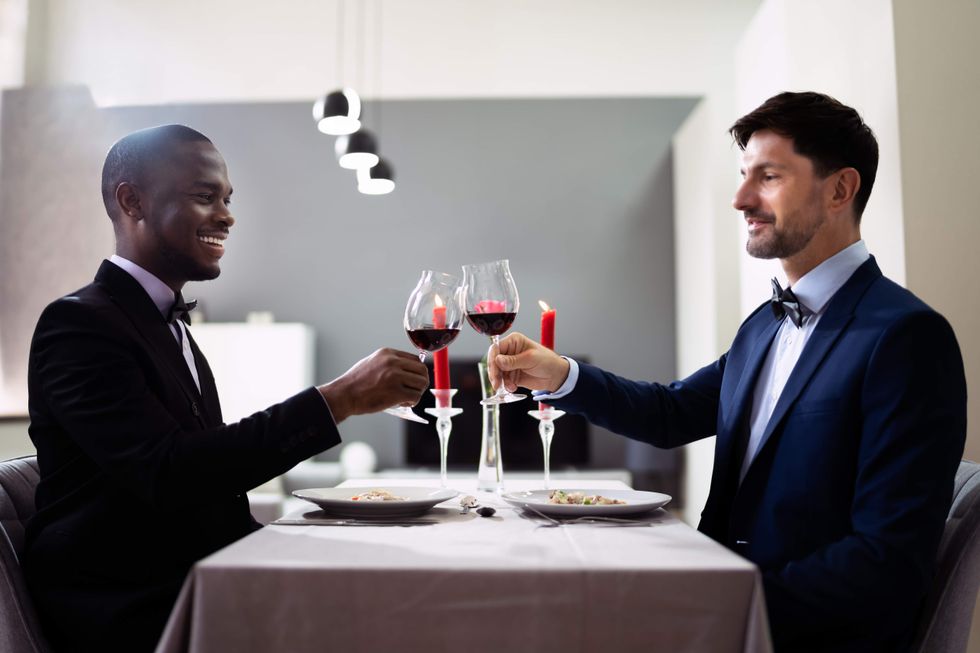 Two men toasting with wine glasses at a restaurant