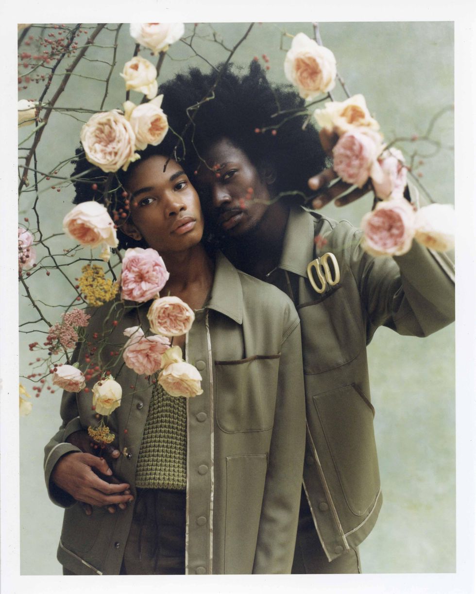 Two models dressed in Fendi holding flowers.