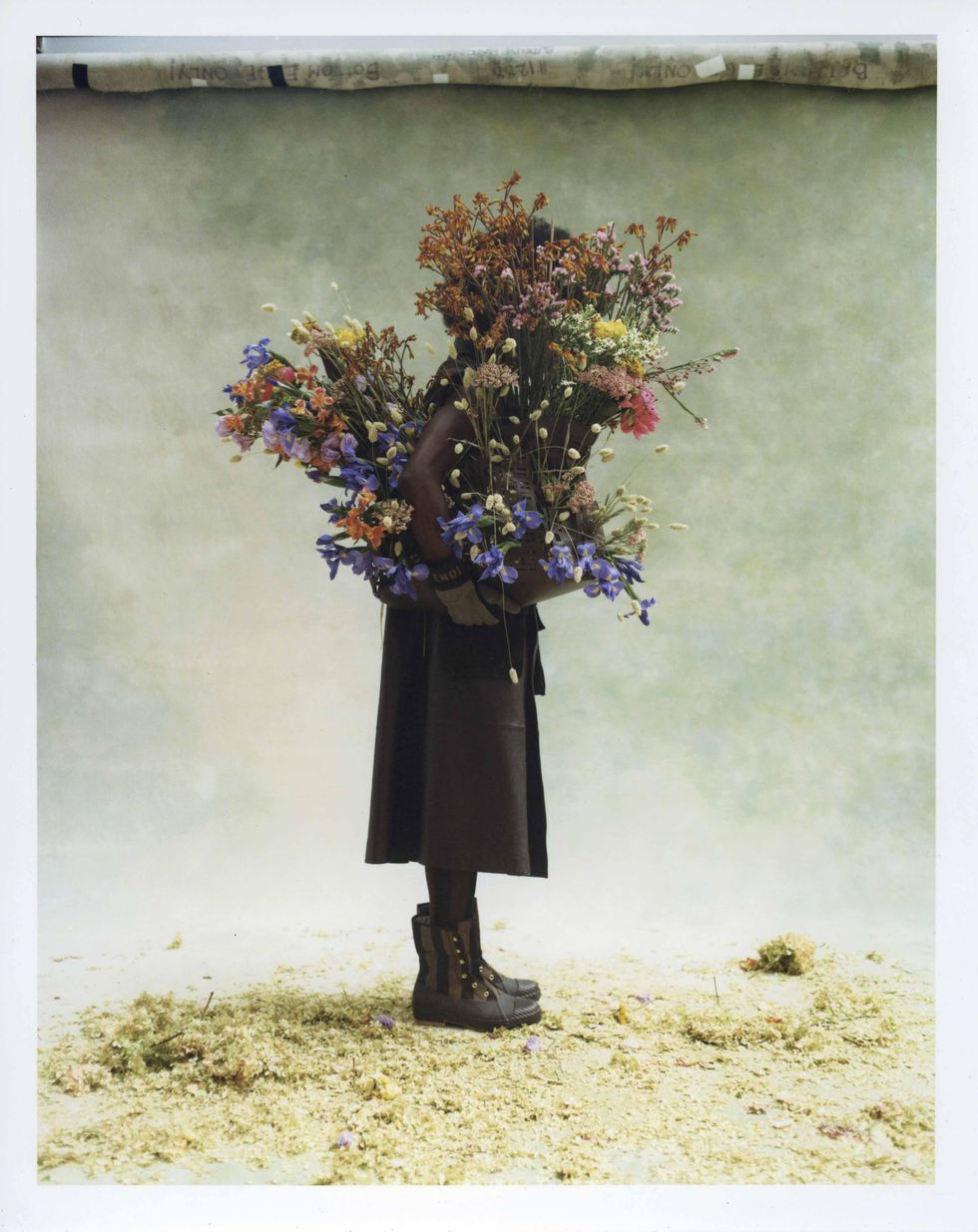 Two models dressed in Fendi holding flowers.