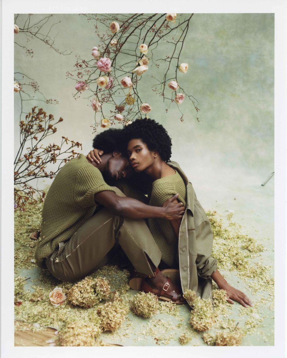 Two models dressed in Fendi holding flowers.