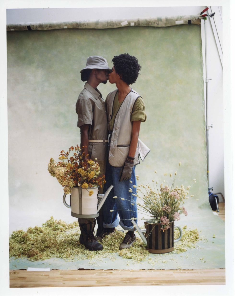 Two models dressed in Fendi holding flowers.