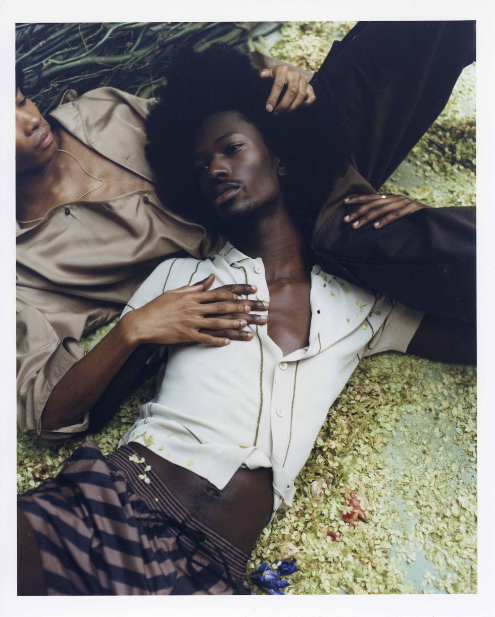 Two models dressed in Fendi holding flowers.