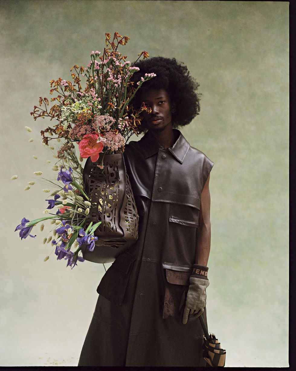 Two models dressed in Fendi holding flowers.