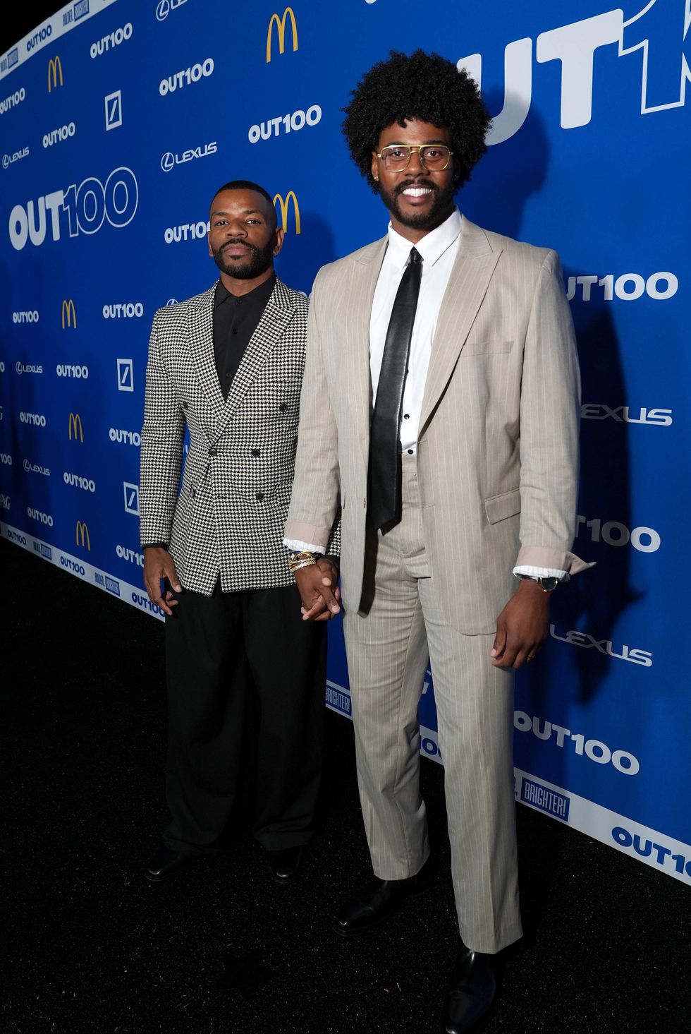 Two people posing on a red carpet