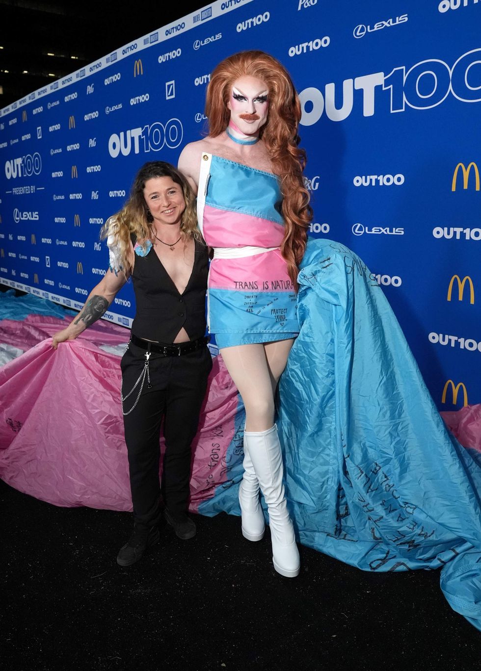 Two people posing on a red carpet