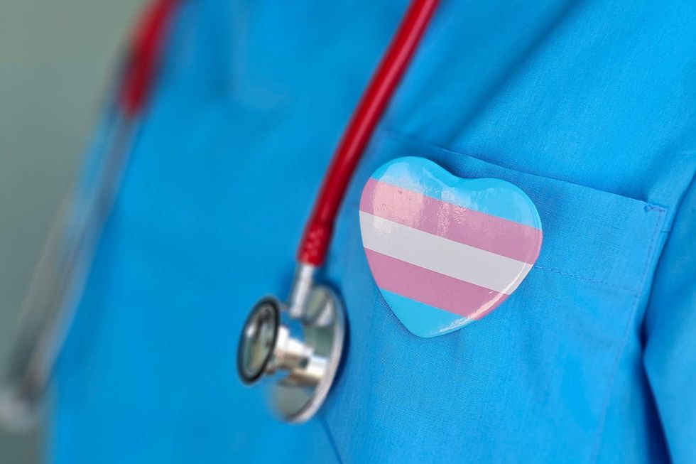 \u200bA stethoscope and a trans pride heart-shaped pin