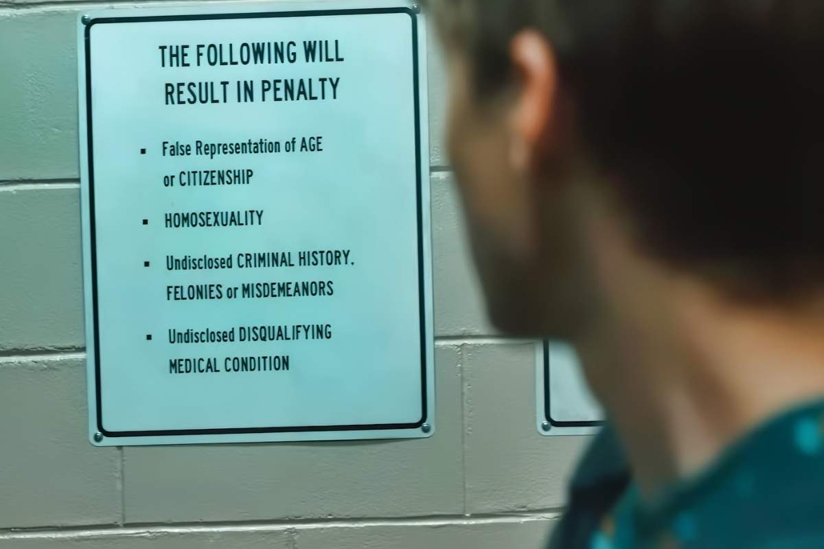 \u200bMiles Heizer as Cameron Cope reads a sign that lists homosexuality as something that would result in a penalty, as seen on \u200bBoots\u200b