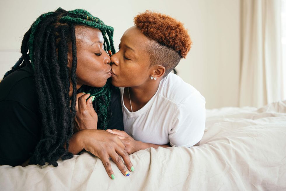 \u200bTwo lesbians kissing while lying in bed