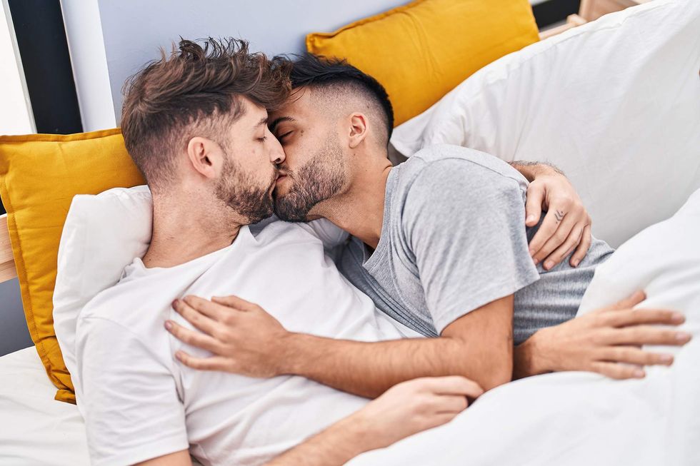 \u200bYoung gay couple kissing in bed.