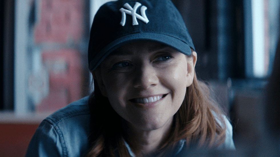 Valorie Curry smiles while wearing a New York Yankees cap in a scene from The Boys