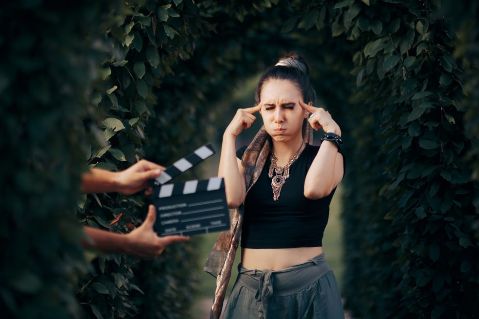 Woman holding her temples on a film set