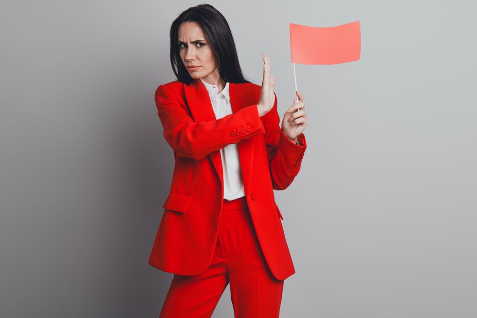 Woman in a red suit holding a red flag