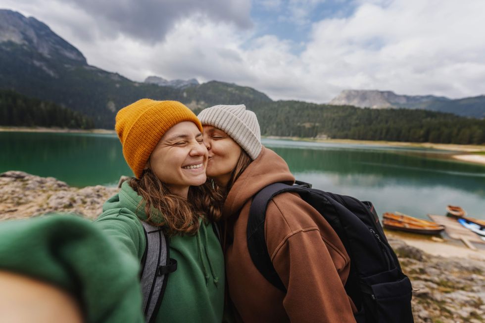 Woman kissing another woman's cheek
