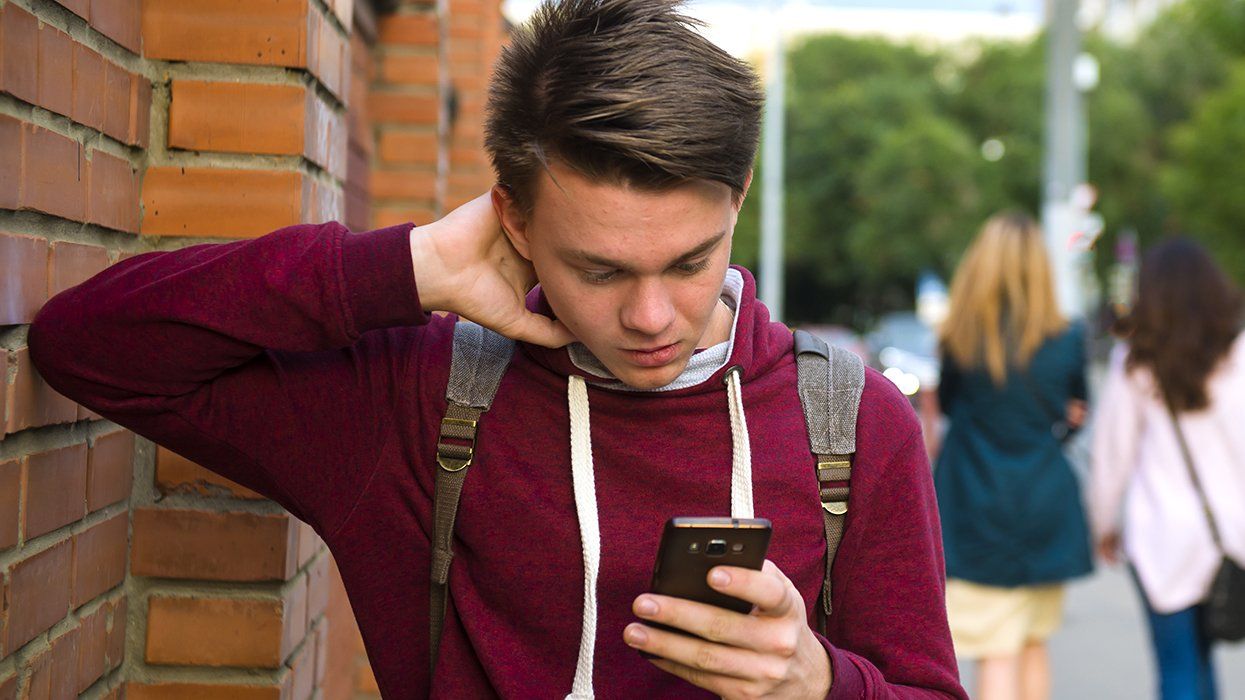worried teen checking cell phone