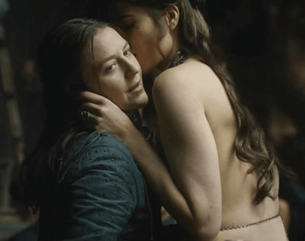 Yara Greyjoy being kissed by a woman in a brothel