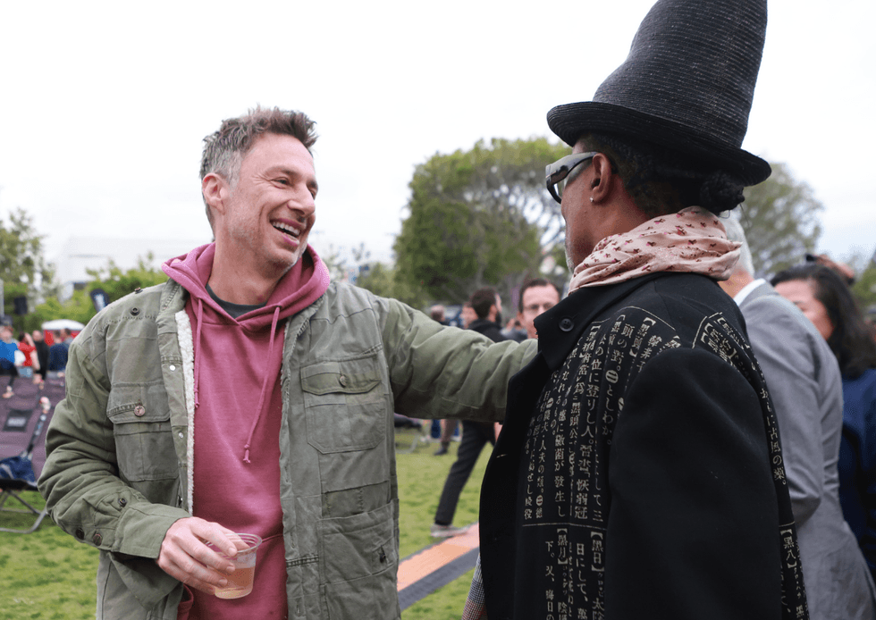 Zach Braff smiles while greeting Billy Porter at The Broken Hearts Club 25th anniversary event in West Hollywood
