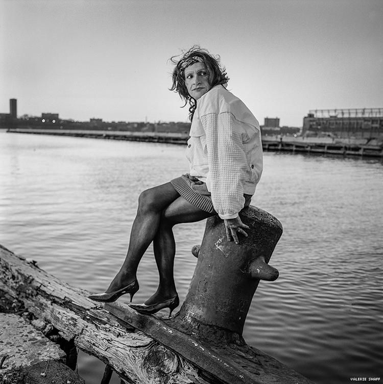 Sylvia Rivera sitting seaside, on a broken dock