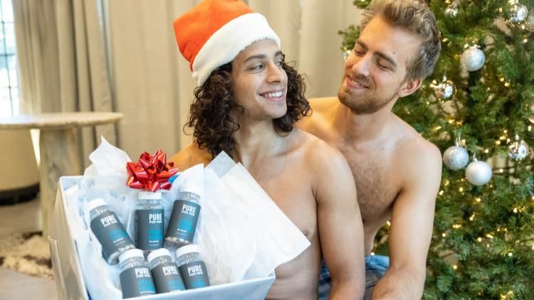 One male gifting another male a bundle of Pure For Men supplements for the holiday season